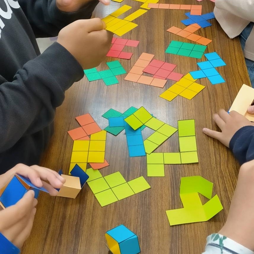 立方体の展開図を探す小学生たち（工作の教室での様子2）